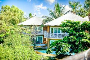 a house with a swimming pool in the middle of trees at Balafon Beach Resort in Kololi