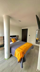 a bedroom with a large bed with an orange blanket at LourdesInn65 in Bogotá