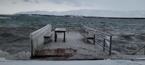 a pier with a table and benches in the water at Sevan lake view in Tsovagyugh
