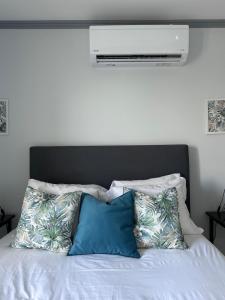 a white bed with two blue pillows on it at Harmonia Guest House in Ponta Delgada