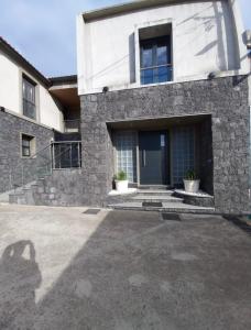 a large stone house with a blue door at Harmonia Guest House in Ponta Delgada