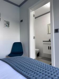 a bedroom with a blue bed and a blue chair at Harmonia Guest House in Ponta Delgada