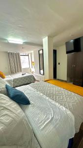 two beds in a large room with at LourdesInn65 in Bogotá +7 photos