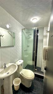 a bathroom with a toilet and a sink and a shower at LourdesInn65 in Bogotá