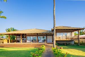 a house with a porch and palm trees at Casa Mandala Corumbau in Corumbau