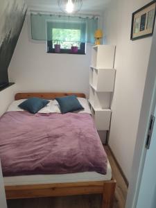 a bedroom with a bed with purple sheets and boxes at Bieszczadzkie Asy in Polana