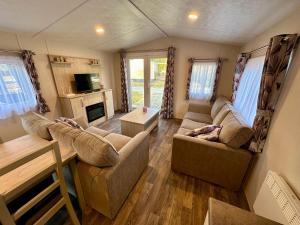 a living room with two couches and a tv at Chalet Jersey in Lauwersoog