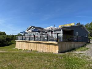 a building with a deck on the side of a field at Buoy & Arrow Suites in Rocky Harbour