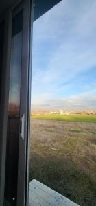 a view of a field through a sliding glass door at Hotel kleo Airport tirana in Tirana