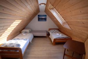 a attic room with two beds and a table at Pod Tatrami widok na Tatry, sauna, parking, blisko Term Bukovina in Bukowina Tatrzańska