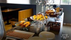 a buffet with three plates of food on a table at INN TERRAÇO Hotel in Mirandópolis