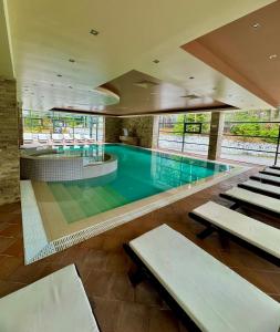 a swimming pool with benches in a building at SPA Apartment Alex in Borovets