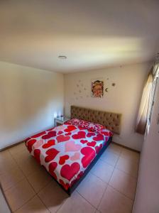 a bedroom with a bed with a red and white comforter at Apartamento turistico diana in La Tebaida +12 photos