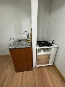 a kitchen with a sink and a shelf in a room at Central Apartment in Cochrane +5 photos
