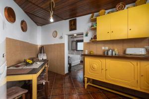 a kitchen with yellow cabinets and a counter top at Dust in The Wind Sunrise in Triovasálos