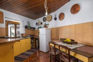 a kitchen with a table and a white refrigerator at Dust in The Wind Sunrise in Triovasálos