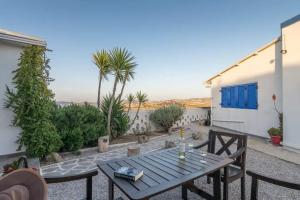 a patio with a wooden table and chairs at Dust in The Wind Sunrise in Triovasálos