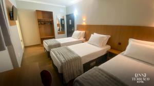 a hotel room with two beds and a chair at INN TERRAÇO Hotel in Mirandópolis +23 photos
