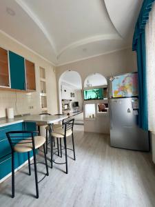 a kitchen with a table and chairs and a refrigerator at Villa Trypill in Tripolʼye