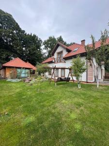a house with a yard with green grass at Villa Trypill in Tripolʼye