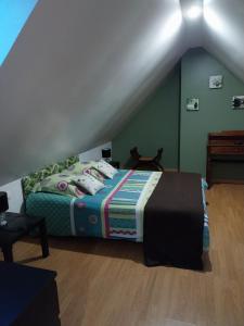a bedroom with a bed with a colorful blanket at Gîte - La campagne in Sainte-Hélène-Bondeville