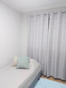 a bedroom with a bed with a white curtain at Juhh Bella Condomínio in Botucatu