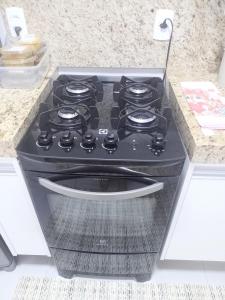 a black stove top oven in a kitchen at Juhh Bella Condomínio in Botucatu