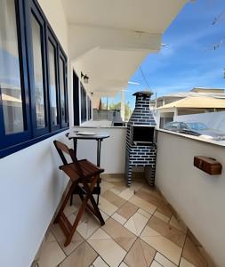 a small balcony with a table and a chair at Casinhas da toca in Búzios