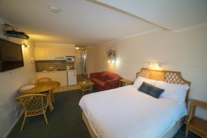 ein Hotelzimmer mit einem Bett und einer Küche in der Unterkunft Shearwater Resort in Port Sorell
