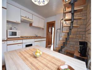 a kitchen with a table with a bowl of fruit on it at Gemütliches Ferienhaus mit Pool in Blankenburg in Blankenburg