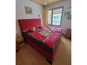 a bedroom with a red bed in a room at Gemütliches Ferienhaus mit Pool in Blankenburg in Blankenburg