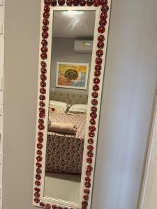a mirror with red roses on a white wall at Pousada Luar in Chapada dos Guimarães +139 photos