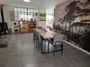a dining room with a wooden table and chairs at Villa Nelson Classée 3 étoiles in Moliets-et-Maa