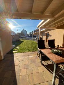 a patio with a wooden table and chairs and a lawn at Gästehaus Auszeit in Riesa