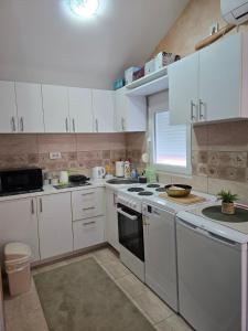 a kitchen with white cabinets and a stove top oven at Gintas Comfort in Podgorica