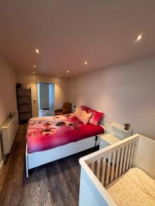 a bedroom with a bed with a red comforter at The perfect spot in Akersloot