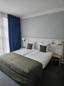 a hotel room with two beds and a window at Hotel Boomgaard in Lanaken