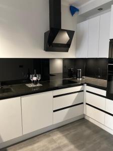 a kitchen with white cabinets and black counter tops at CentralPark in Kostrzyn nad Odrą