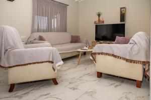 a living room with two chairs and a couch at Green Yard House in Alexandroupoli