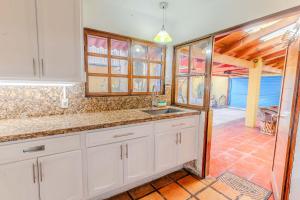 a kitchen with white cabinets and a sink at Casa Hidalgo Hideaway in Chapala +21 photos