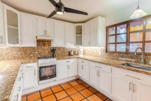 a kitchen with white cabinets and a ceiling fan at Casa Hidalgo Hideaway in Chapala