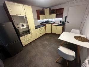 a small kitchen with a table and a refrigerator at Byt v podzámčí in Litomyšl