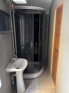 a bathroom with a shower and a white sink at Хостел Гора in Kharkiv