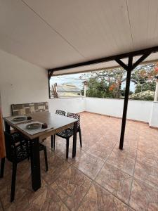 a dining room with a table and chairs on a patio at Casinhas da toca in Búzios