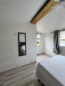 a bedroom with a bed and a mirror on the wall at Casinhas da toca in Búzios