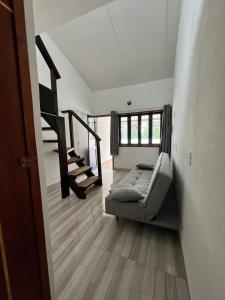 a living room with a bed and a staircase at Casinhas da toca in Búzios