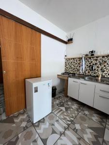 a kitchen with a white refrigerator in a room at Casinhas da toca in Búzios +93 photos
