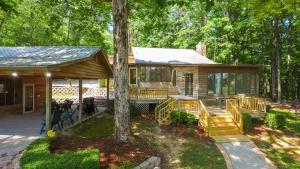 a cabin in the woods with a porch and a tree at Clear Creek Escape - Double Decker Dock, New Green Fishing Lights! in Jasper
