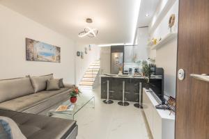 a large living room with a couch and a kitchen at varkiza luxury 2BD apartment in Varkiza