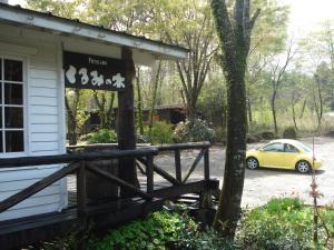a yellow car parked in front of a house at Pension Kurumi no Ki in Toyooka